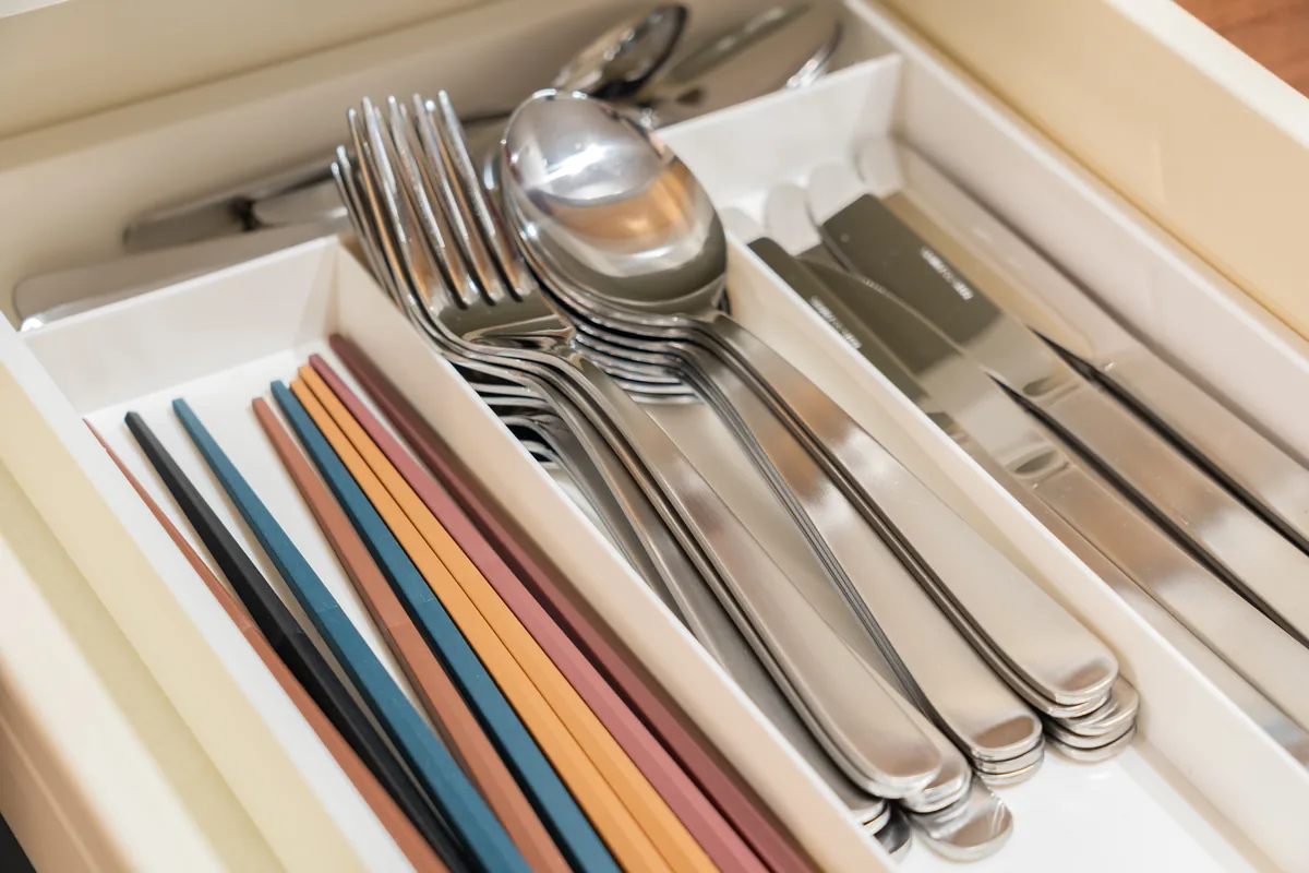 Chopsticks and cutlery laid ready in a drawer